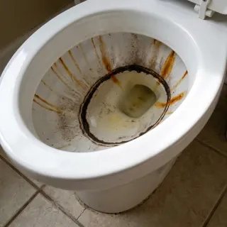 Toilette mit dunklem Kalkring und Rostschlieren vor der Anwendung